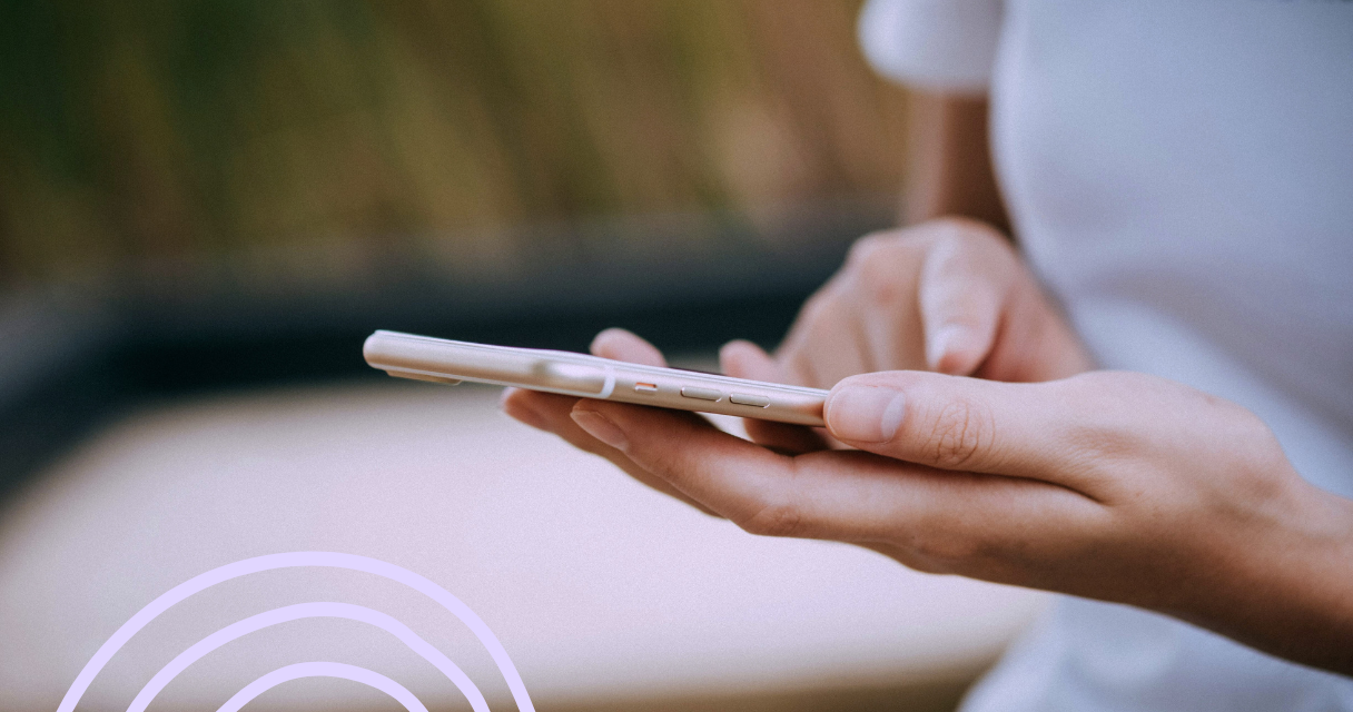 A close-up of hands holding a smartphone, searching for deals or making purchases online for last-minute shopping.