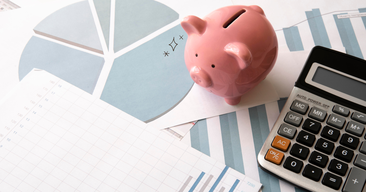 Pink piggy bank and calculator on financial charts representing credit score factors and money management.